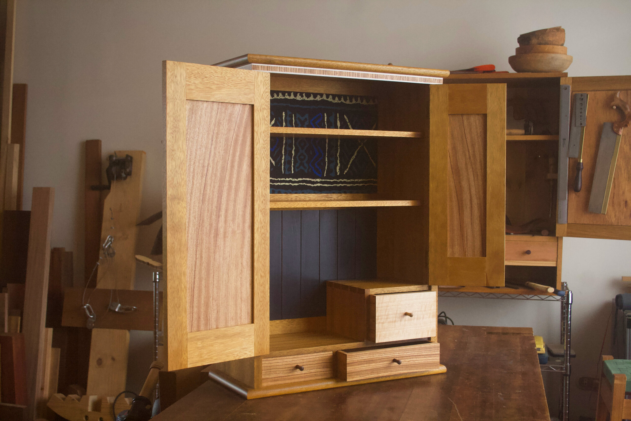 Gabinete con puertas abiertas mostrando los cajones los estantes y el fondo